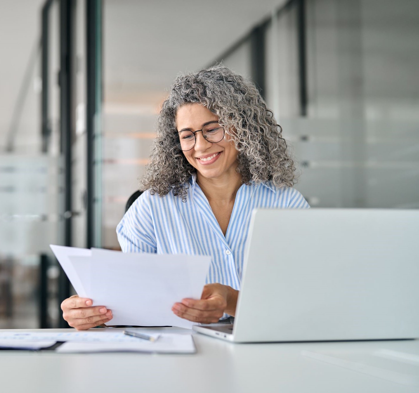 Business woman reviewing documents sitting at a dask